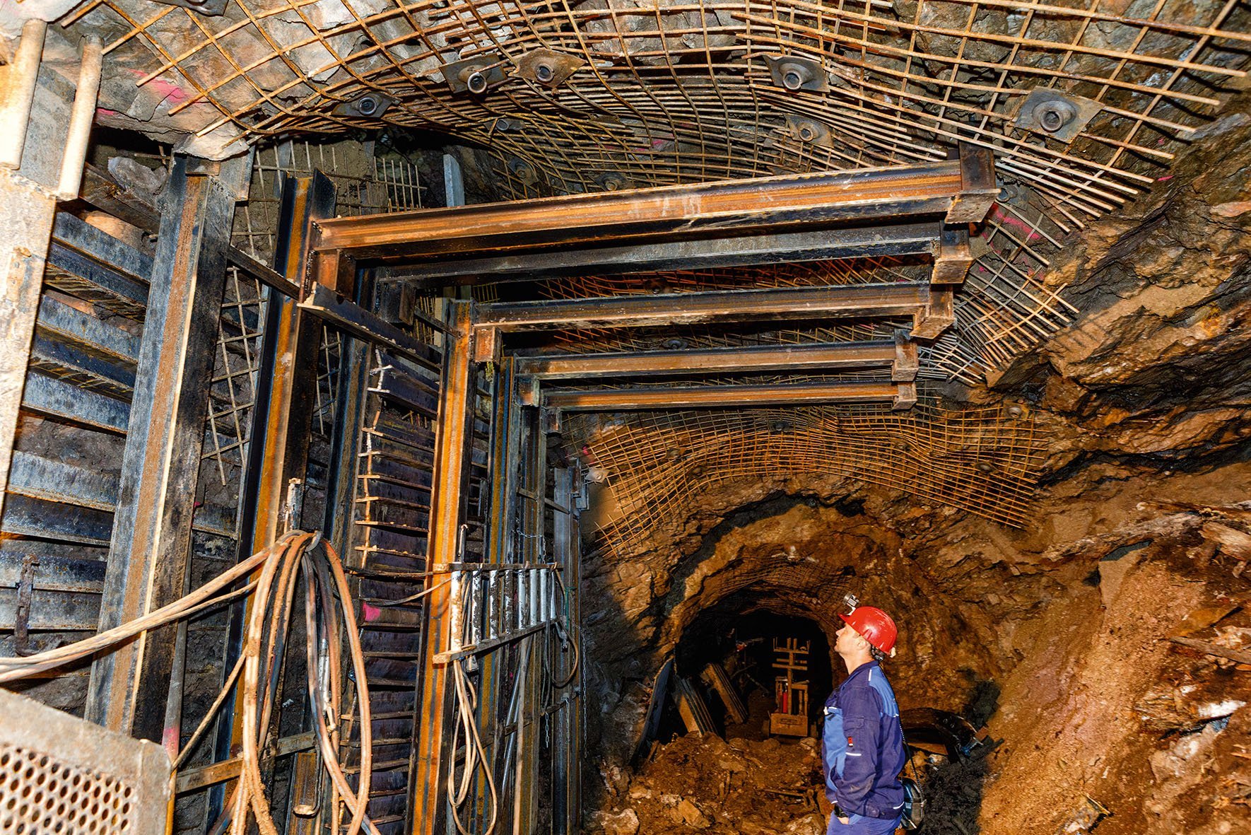 Ein Bergmann betrachtet eine Stahlkonstruktion unter Tage