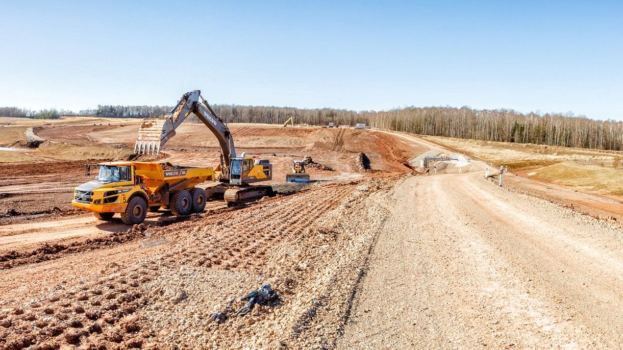 Bagger und Dumper neben einer Fahrtradde, die in den Einschnitt führt