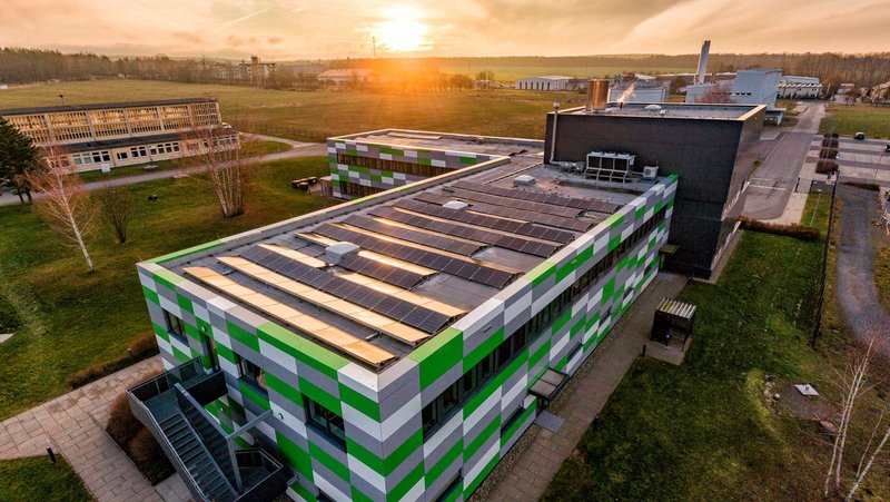 Luftbild. Das Funktionalgebäude mit der untergehenden Sonne.