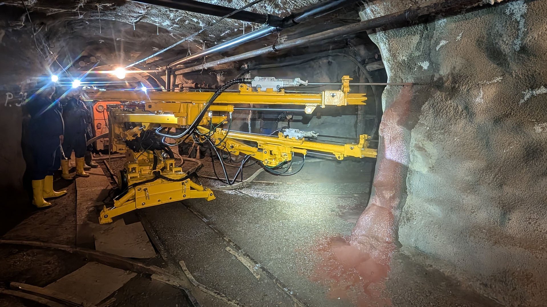 Mit dem Bohrwagen werden zwei Löcher in die Wand einer Strecke unter Tage gebohrt