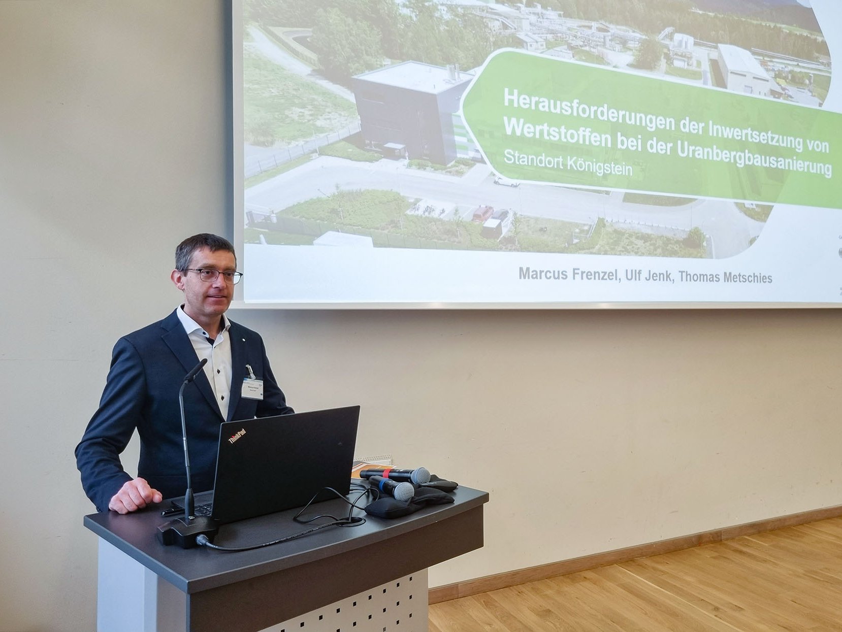 Ein Mann am Rednerpult vor einer Präsentation