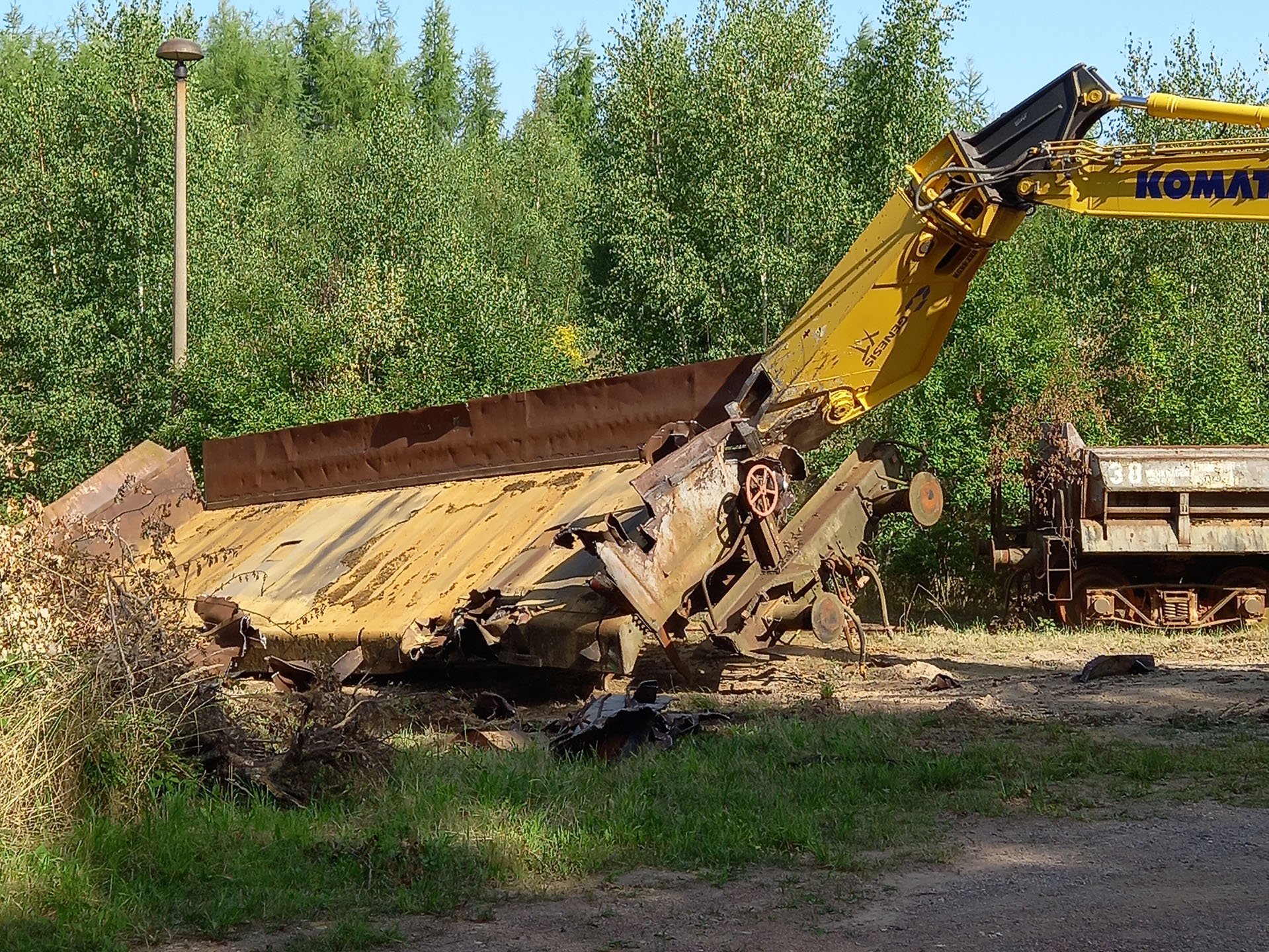 Eine Hydraulikschere an einem Ausleger zerschneidet einen Wagon