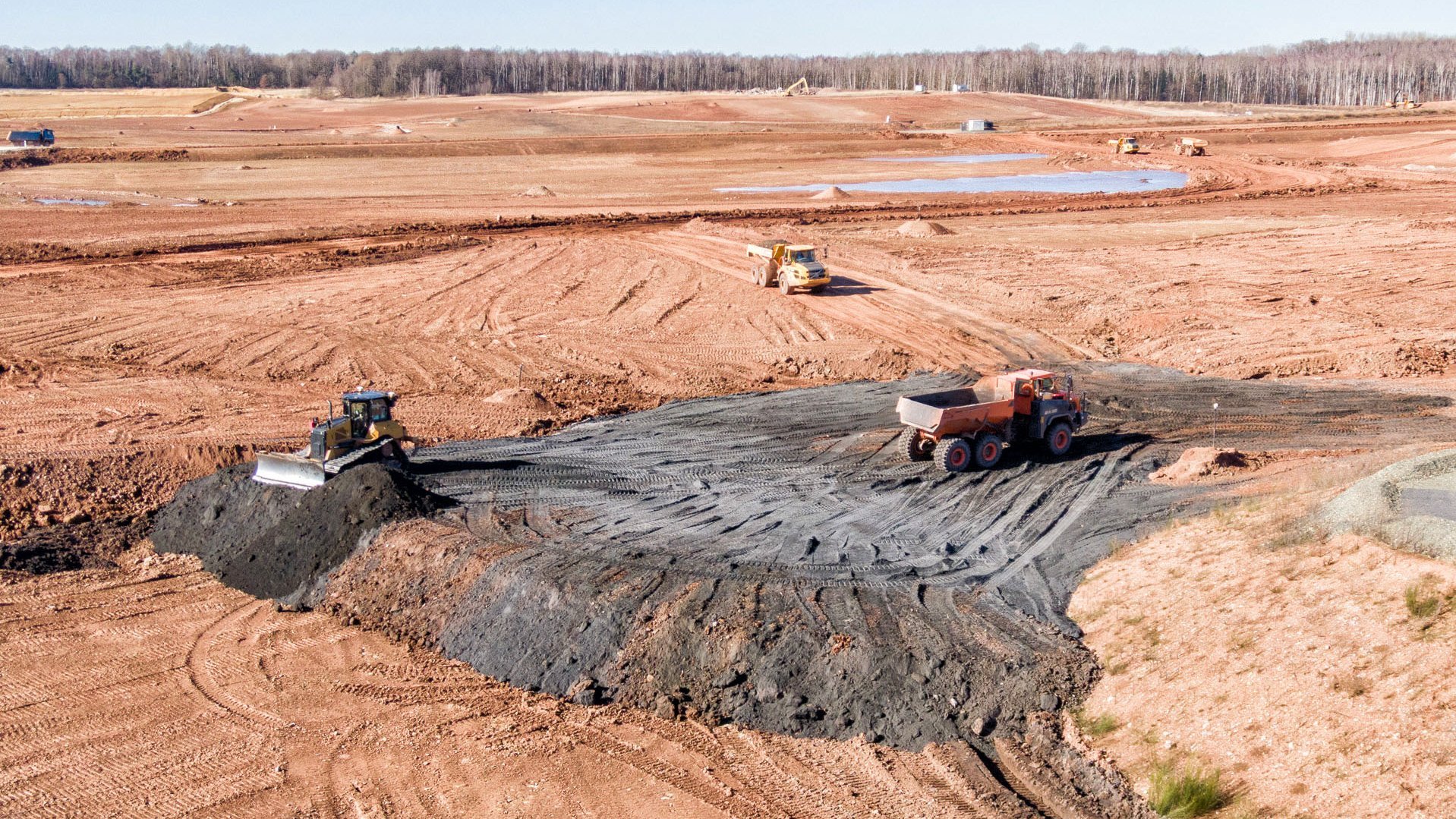 Tailings werden abgeladen und mit einer Raupe planiert